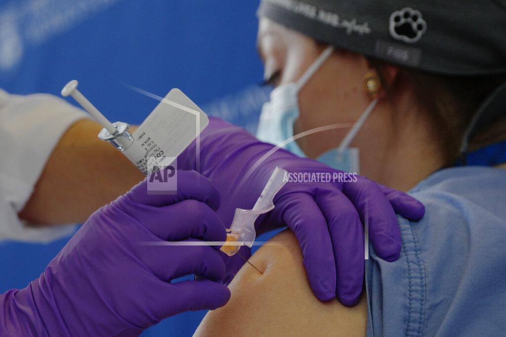 Catalina Gonzalez-Marques, an emergency medical physician, receives the Pfizer-BioNTech coronavirus vaccine at Brigham and Women's Hospital, Wednesday, Dec. 16, 2020, in Boston. (Brian Snyder/Pool via AP)