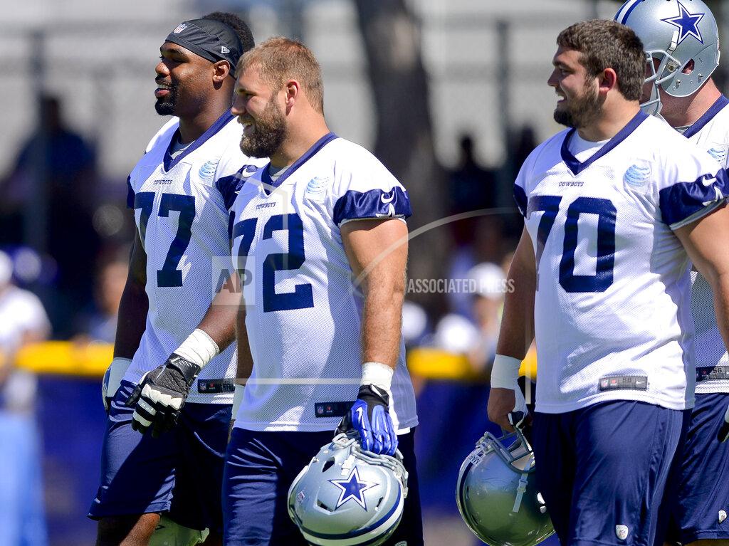 FILE - In this July 24, 2014, file photo, Dallas Cowboys offensive tackle Tyron Smith (77), center Travis Frederick (72) and guard Zack Martin (70) take the field for afternoon practice during an NFL football training camp in Oxnard, Calif. The Cowboys invested heavily in their offensive line and have become consistent winners behind the unit with the NFL’s highest salary-cap figure. While Dallas isn’t the only example of a club benefiting from a heavy investment up front, the New England Patriots are several notches higher than Dallas as an elite team with a more frugal approach. (AP Photo/Gus Ruelas, File)