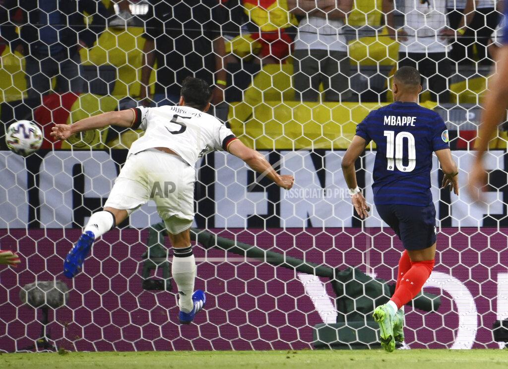 Franck Fife France's Kylian Mbappe, right, looks as Germany's Mats Hummels scores an own goal during the Euro 2020 soccer championship group F match between Germany and France at the Allianz Arena stadium in Munich, Tuesday, June 15, 2021. (Franck Fife/Pool via AP)