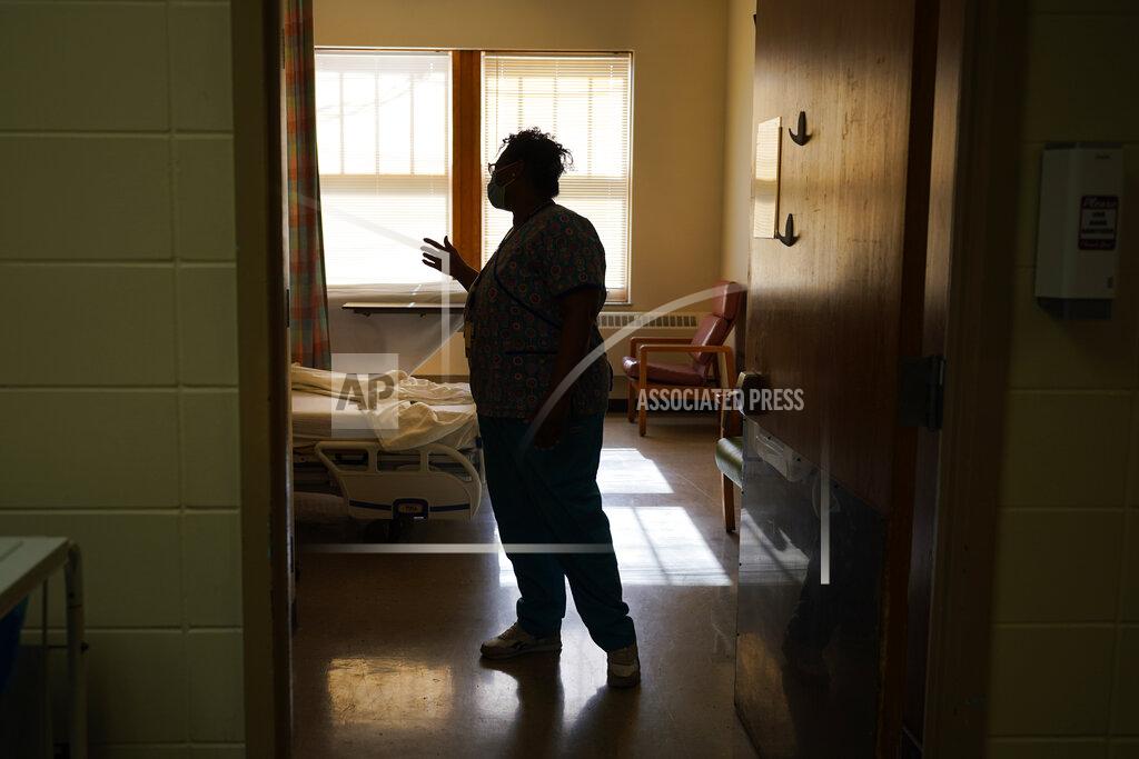 Charles Rex Arbogast Roseland Community Hospital RN Rhonda Jones checks in on a patient Friday, Jan. 29, 2021, at the South Side of Chicago hospital. Jones has treated many patients with severe COVID-19, a relative died from it, and her mother and a nephew were infected and recovered, but she is still holding out getting the vaccine. (AP Photo/Charles Rex Arbogast)