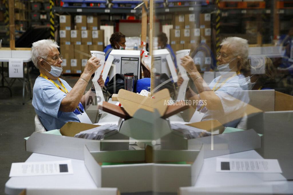 FILE - In this June 9, 2020, file photo election workers process mail-in ballots during a nearly all-mail primary election in Las Vegas. As President Donald Trump's reelection campaign challenged Nevada's new voting law in court, the president and Republicans argued the rules would facilitate fraud and illegal voting. Chief among their volley of criticism was the law's provision allowing “ballot harvesting." The Nevada lawsuit highlighted a practice that has long fueled Republicans' suspicions about the dangers of mail-in voting. (AP Photo/John Locher, File)