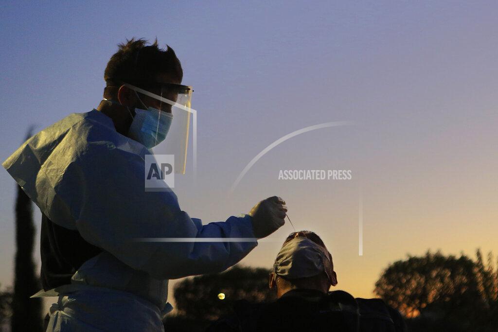 Petros Karadjias A health worker carries out a rapid coronavirus test at a car-parking in Lakatamia a suburb west of capital Nicosia, Cyprus, Thursday, Dec. 10, 2020. Cyprus' Health Minister Constantinos Ioannou said Wednesday that an island-wide night time curfew would be extended through December while bars, restaurants and shopping malls would be shut, high school students would stay at home for online classes and church services would be without worshippers amid concerns that a sustained spike in coronavirus infections hasn't receded despite restrictions. (AP Photo/Petros Karadjias)