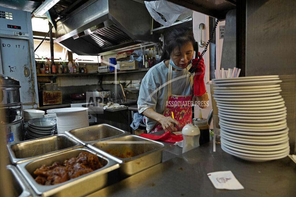 Vincent Yu A restaurant employee takes phone orders at a Chinese food court in Hong Kong, Wednesday, July 29, 2020. Hong Kong has banned dining-in at restaurants completely on Wednesday and make it mandatory to wear masks in all public places, as the city battles its worst coronavirus outbreak to date. (AP Photo/Vincent Yu)