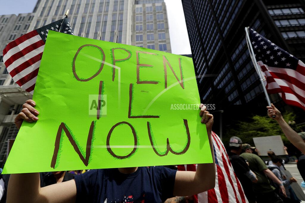 A protester holds a sign during a reopen Illinois rally outside Thompson Center in downtown Chicago, Saturday, May 16, 2020, during the coronavirus pandemic. (AP Photo/Nam Y. Huh)