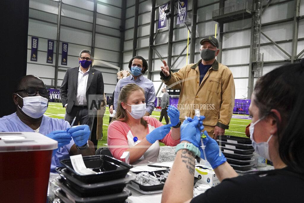 Minnesota Gov. Tim Walz stopped to watch as medical professionals drew doses he took a tour of the Vikings Training Center that'd been converted into a site administering the newly available, single-dose, Johnson & Johnson COVID-19 vaccine Friday, March 5, 2021, in Eagan, Minn. (Anthony Souffle/Star Tribune via AP)