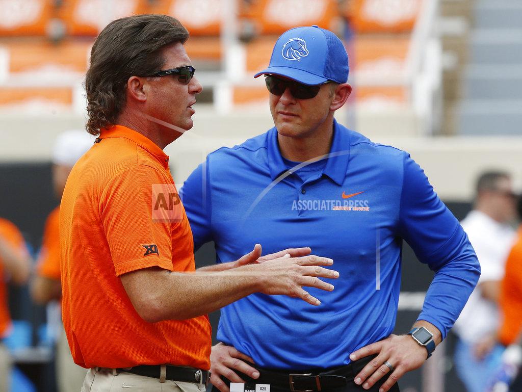 Oklahoma State head coach Mike Gundy, left, talks with Boise State head coach Bryan Harsin, right, before their NCAA college football game in Stillwater, Okla., Saturday, Sept. 15, 2018. (AP Photo/Sue Ogrocki)