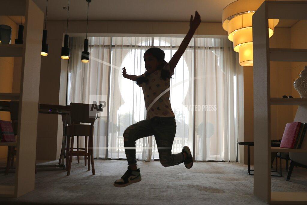 Kamran Jebreili Michelle Rasul jumps around in the lobby of her apartment building in Dubai, United Arab Emirates, Sunday, May 9, 2021. Rasul, a 9-year-old girl from Azerbaijan who lives in Dubai, is scratching her way to the top as a DJ after competing in the DMC World DJ Championship. (AP Photo/Kamran Jebreili)