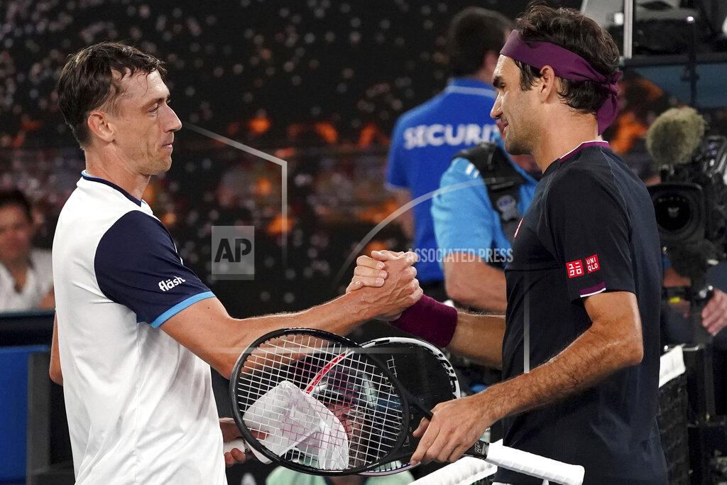 FILE - In this Jan. 25, 2020, file photo, Australia's John Millman, left, shakes hands with Switzerland's Roger Federer following their match at the Australian Open tennis championship in Melbourne, Australia. Just four matches after his five-setter against Federer on one of the biggest stages in tennis, Millman was having to scramble to find a practice court. (AP Photo/Lee Jin-man, File)