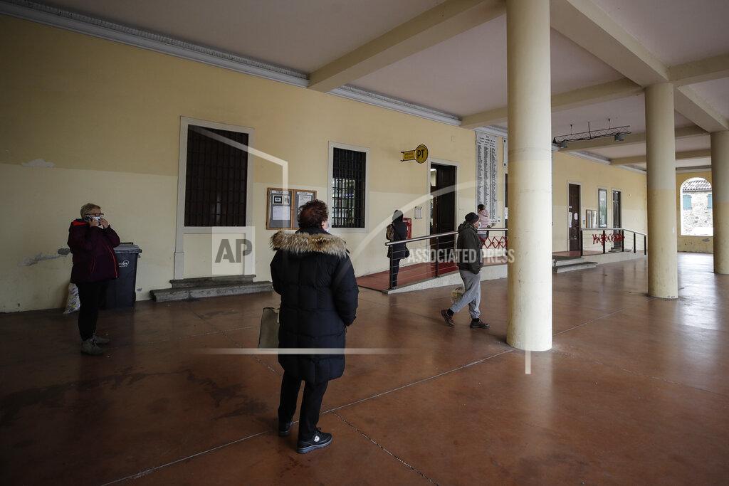 Luca Bruno People queue at the post office in Vo Euganeo, Italy, Wednesday, Feb. 10, 2021. Shockwaves ran through the wine-making village of Vo, west of Venice, as word spread last Feb. 21 that a retired roofer had died of the new coronavirus becoming the first known COVID-19 victim in the West. (AP Photo/Luca Bruno)