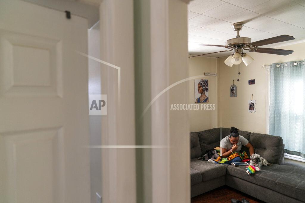 David Goldman Darelyn Maldonado, 12, sits on the couch with her dog, Lisa, at her home in Pawtucket, R.I., Wednesday, March 3, 2021. Maldonado, a seventh grade student, has been out of in person school for a year since the pandemic began. She feels like she's lost friends over the past year, has missed out on playing softball which she loves and just wants her life to go back to normal. (AP Photo/David Goldman)