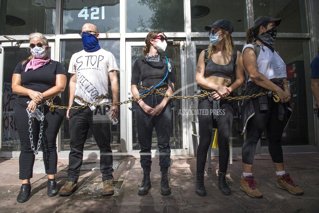 Chris Granger New Orleans Renters Rights Assembly protesters chain themselves together outside an entrance to First City Court near New Orleans City Hall on Thursday, July 30, 2020. (Chris Granger/The Advocate via AP)