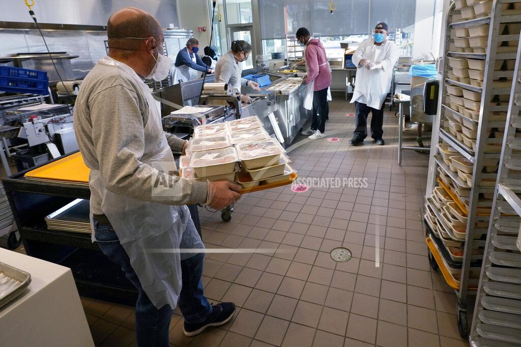 Charles Krupa Volunteers prepare meals at Community Servings, which prepares and delivers scratch-made, medically tailored meals to individuals & families living with critical & chronic illnesses, Tuesday, Jan. 12, 2021, in the Jamaica Plain neighborhood of Boston. Food is a growing focus for insurers as they look to improve the health of the people they cover and cut costs. Insurers first started covering Community Servings meals about five years ago, and CEO David Waters says they now cover close to 40%. (AP Photo/Charles Krupa)