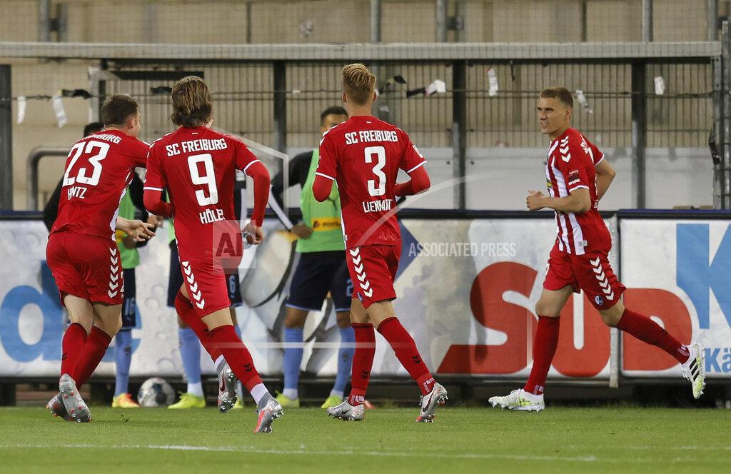 Ronald Wittek Freiburg's Nils Petersen, right, celebrates with teammates after scoring the opening goal during the German Bundesliga soccer match between SC Freiburg and Borussia Moenchengladbach in Freiburg, Germany, Friday, June 5, 2020. Because of the coronavirus outbreak all soccer matches of the German Bundesliga take place without spectators. (Ronald Wittek/Pool via AP)