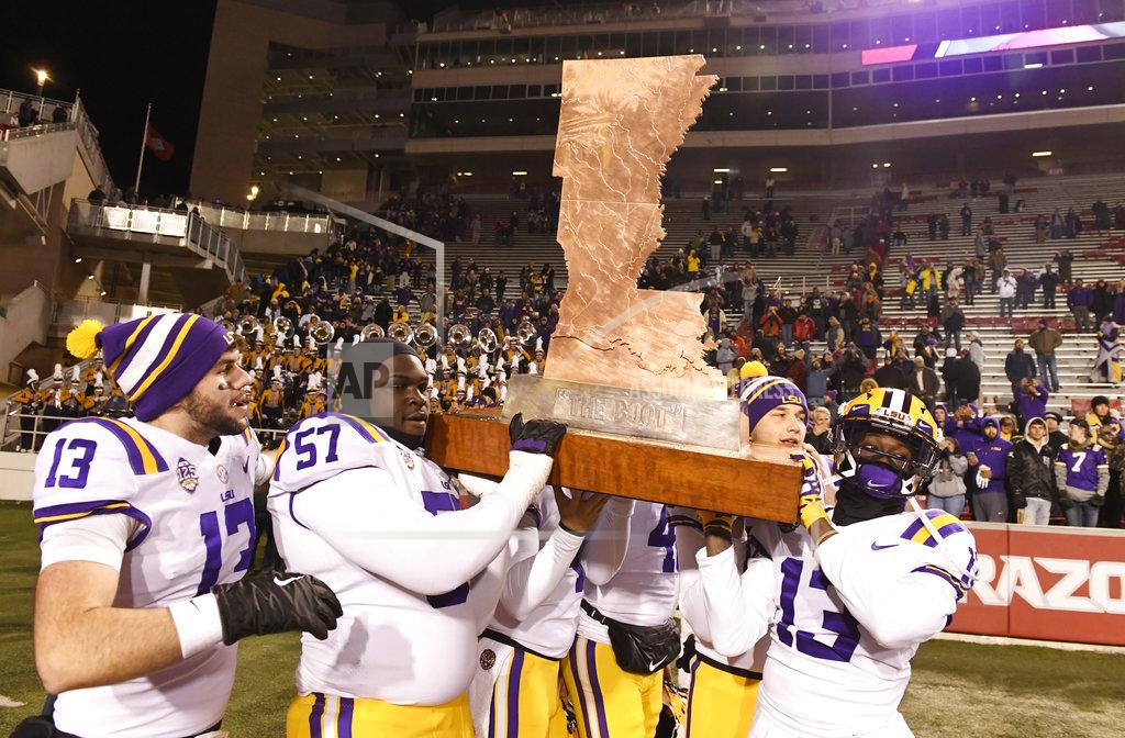 Michael Woods LSU players Andre Sale (13), Chasen Hines (57) and Jontre Kirklin, right, help carry off the Boot trophy after beating Arkansas 24-17 during an NCAA college football game, Saturday, Nov. 10, 2018, in Fayetteville, Ark. (AP Photo/Michael Woods)