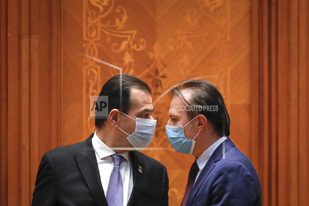 Vadim Ghirda Romanian prime minister-designate Florin Citu, right, and former premier Ludovic Orban arrive for a parliament session called to vote on a new government team in Bucharest, Romania, Wednesday, Dec. 23, 2020. Romania's president Klaus Iohannis appointed on Tuesday, the outgoing finance minister as prime minister-designate after three pro-Western center-right groups joined forces to keep out of power a left-leaning populist party that won most votes at a parliamentary election earlier this month. (AP Photo/Vadim Ghirda)