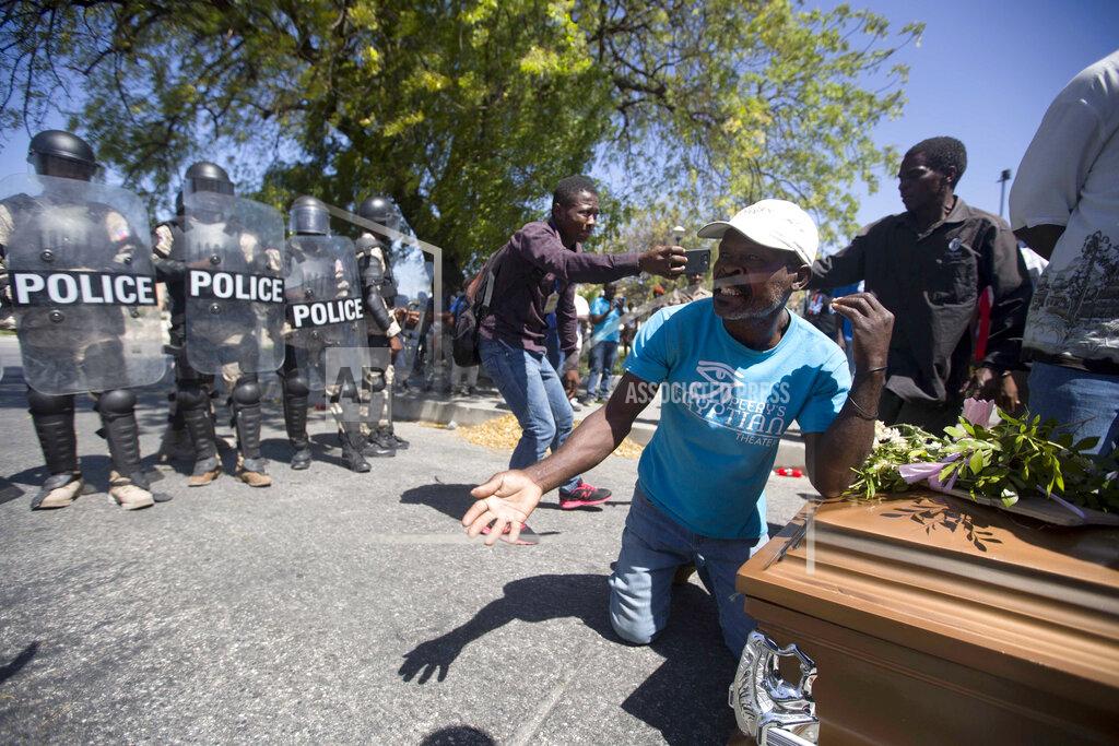 Dieu Nalio Chery Demonstrators arrive in front of the National Palace carrying a coffin containing the body of a protester who was killed during the week's previous protests, as national police stop them, in Port-au-Prince, Haiti, Friday, Feb. 22, 2019. Protesters are angry about skyrocketing inflation and the government's failure to prosecute embezzlement from a multi-billion Venezuelan program that sent discounted oil to Haiti. (AP Photo/Dieu Nalio Chery)