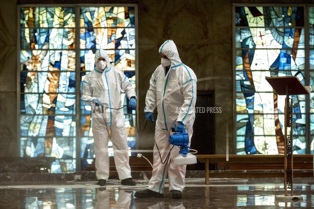 Italian Army and Rome's street cleaning task force personnel sanitize a church to prevent the spread of COVID-19, in Rome, Wednesday, May 13, 2020. Italy partially lifted lockdown restrictions last week after a two-month lockdown and onn May 18 churches are preparing to reopen to the public for masses. (Roberto Monaldo/LaPresse via AP)