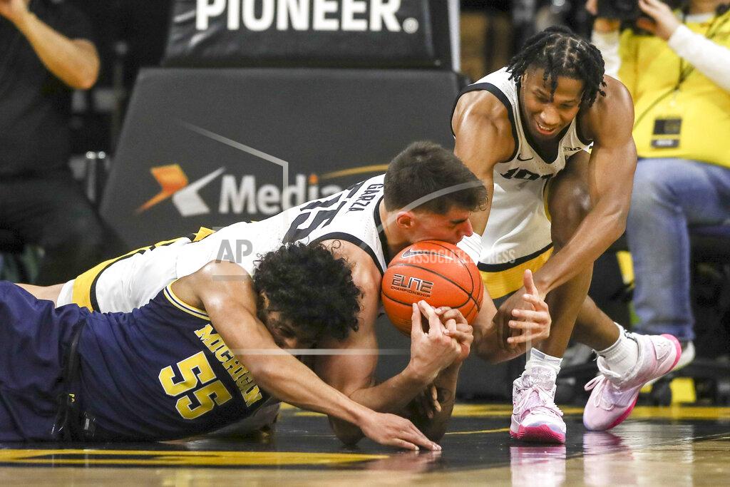 Rebecca F. Miller Iowa center Luka Garza (55) and guard Bakari Evelyn (4) and Michigan guard Eli Brooks (55) go after the ball during the firt half of an NCAA college basketball game Friday, Jan. 17, 2020, in Iowa City, Iowa. (Rebecca F. Miller/The Gazette via AP)
