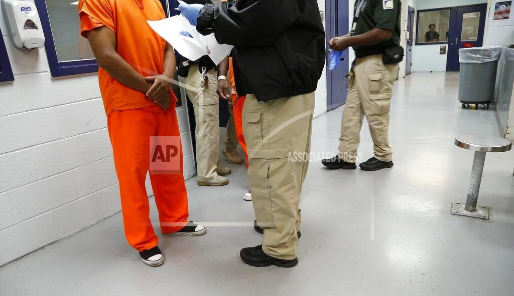 This Sept. 24, 2015 photo shows a detainee is processed by a guard inside the Krome Detention Center in Miami. Under the Trump administration, the country has become increasingly inhospitable for undocumented immigrants and those seeking asylum. But it has also recalibrated the treatment of legal permanent residents — referred to as “green card” holders — and naturalized citizens, affording zero tolerance for transgressions that would have been of little interest under previous administrations. (José A. Iglesias/Miami Herald via AP)