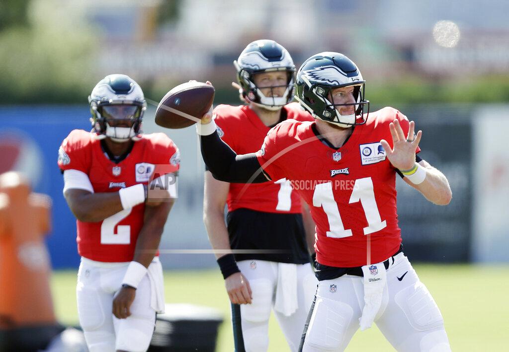 Yong Kim Philadelphia Eagles quarterback Carson Wentz (11) throws the football as backup quarterbacks Nate Sudfeld, center, and Jalen Hurts watch during an NFL football training camp practice in Philadelphia, Monday, Aug. 17, 2020. (Yong Kim/Pool Photo via AP)