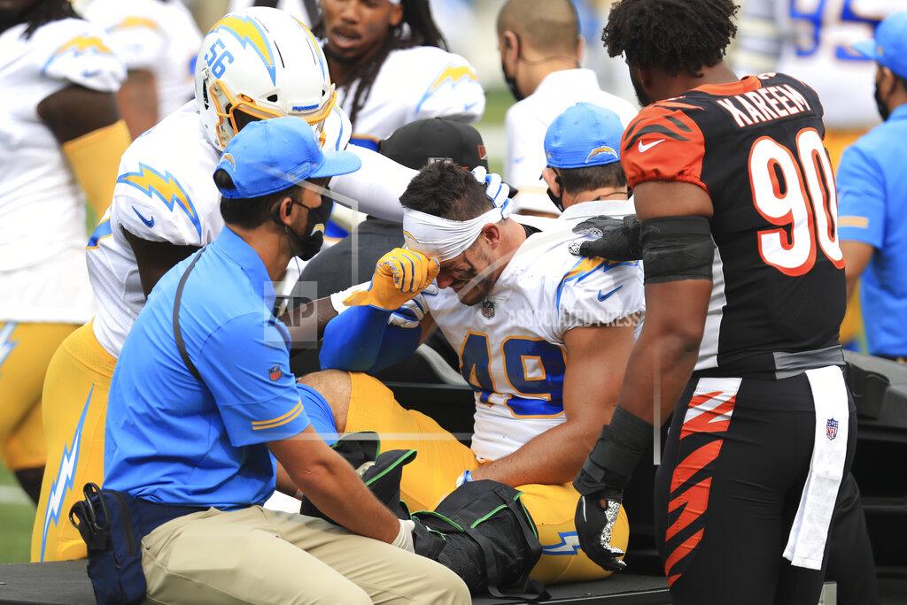 Aaron Doster Los Angeles Chargers linebacker Drue Tranquill (49) is comforted by Kenneth Murray (56) and Cincinnati Bengals' Khalid Kareem (90) after being injured during the first half of an NFL football game, Sunday, Sept. 13, 2020, in Cincinnati. (AP Photo/Aaron Doster)