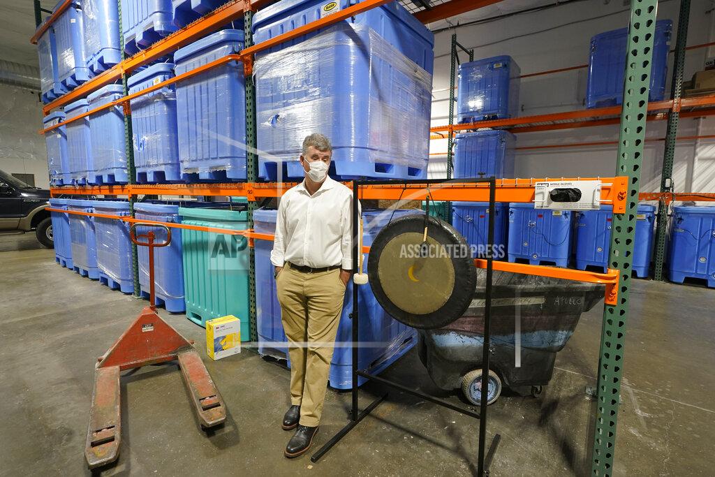 Ted S. Warren Micah Truman, CEO of Return Home, a company that composts human remains into soil, poses for a photo, Wednesday, Sept. 15, 2021, in Auburn, Wash., south of Seattle. At right is a gong that is struck by workers each time a body is placed into the vessel that holds it during the composing process, which is part of a ritual initiated by Truman to preserve the individual dignity of each person trusted to his company's care. Behind him are vessels where remains are kept during the second month of the two-month composing process. Earlier in September, Colorado became the second state after Washington to allow human body composting, and Oregon will allow the practice beginning next July. (AP Photo/Ted S. Warren)