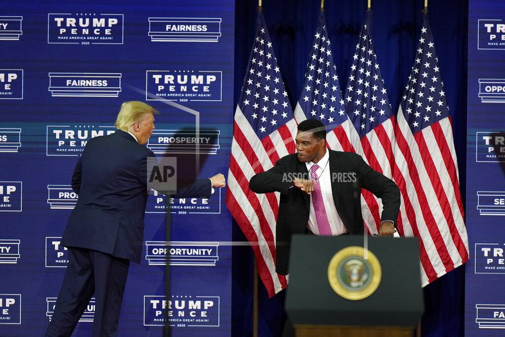 John Bazemore President Donald Trump elbow bumbs with Herschel Walker during a campaign rally, Friday, Sept. 25, 2020, in Atlanta. (AP Photo/John Bazemore)