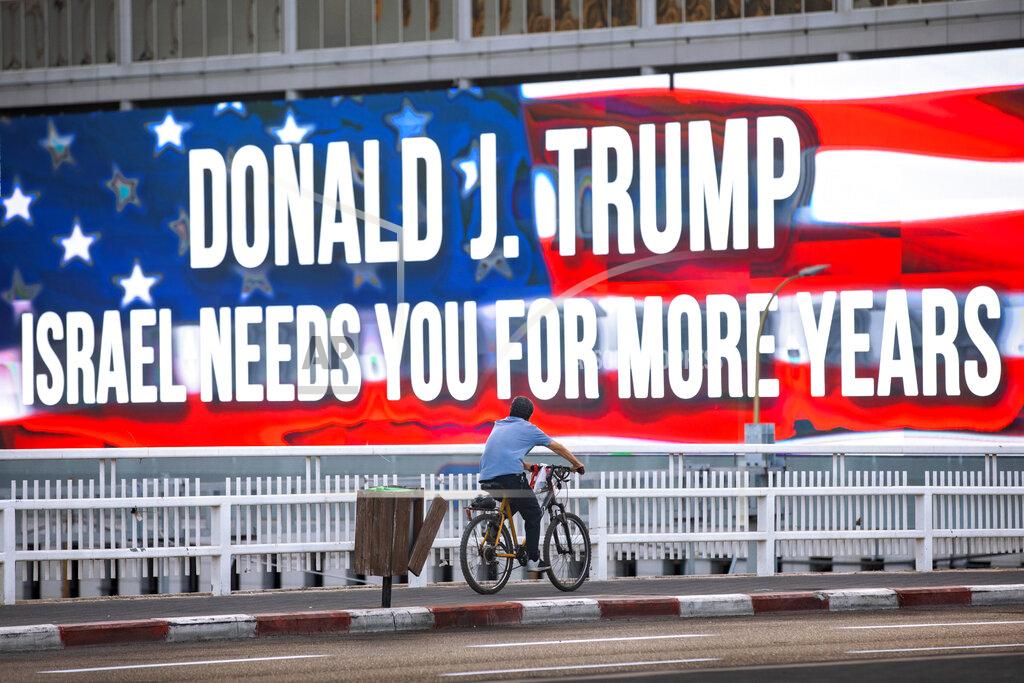 Oded Balilty FILE - In this Oct. 21, 2020 file photo a cyclist rides next to a billboard supporting President Donald Trump, ahed of the U.S presidential election, in Tel Aviv, Israel. Tuesday's U.S. election, what's at stake if Donald Trump's presidency ends — or if it continues? Nation by nation, how is Election Day in the United States being watched, considered, assessed? (AP Photo/Oded Balilty, File)