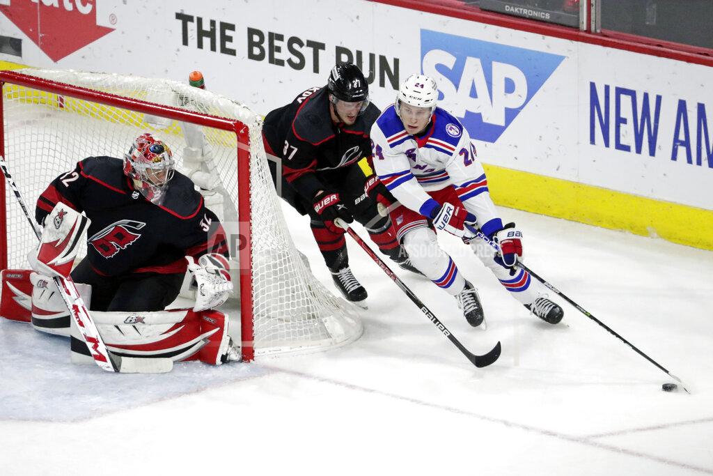 Chris Seward New York Rangers right wing Kaapo Kakko (24) drives against Carolina Hurricanes goaltender Antti Raanta (32) and right wing Andrei Svechnikov (37) during the first period in Game 2 of an NHL hockey Stanley Cup second-round playoff series Friday, May 20, 2022, in Raleigh, N.C. (AP Photo/Chris Seward)