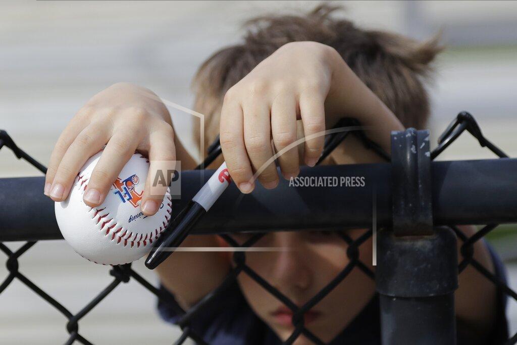 Frank Franklin Ii A young fan waits for a player to sign his baseball during a Philadelphia Phillies spring training baseball workout Friday, Feb. 14, 2020, in Clearwater, Fla. Big league managers say that Major League Baseball has instructed them to prepare for spring training to start on time in mid-February despite uncertainty around the coronavirus. Tampa Bay Rays manager Kevin Cash said Wednesday, Dec. 16, 2020, that officials from the commissioner's office had a meeting with managers Tuesday an expressed optimism about opening spring camps as scheduled.(AP Photo/Frank Franklin II)