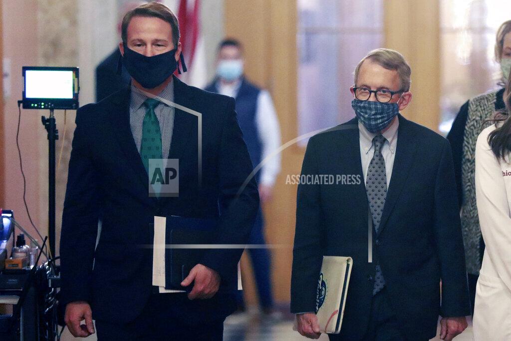 FILE— In this file photo from April 15, 2020, Ohio Lt. Gov. Jon Husted, left, and Gov. Mike DeWine, walk into their daily coronavirus news conference at the Ohio Statehouse in Columbus, Ohio. Husted, a former University of Dayton football player, has been advocating that fall high school sports proceed during the coronavirus pandemic. He tweeted Aug. 10 that good results can't be expected when sports are taken away from young people. Husted's comments come as Gov. DeWine is expected to announce his plans for sports on Tuesday, Aug. 18, 2020. (Doral Chenoweth/The Columbus Dispatch via AP)