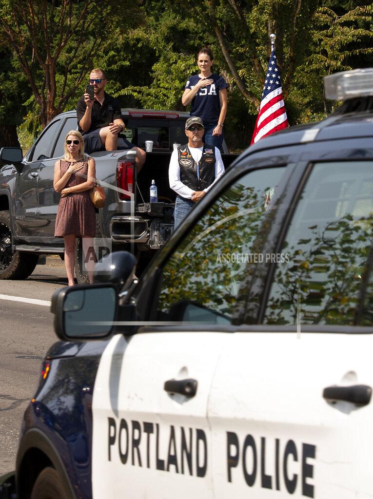 Joshua Hart People look on during a procession to a memorial service for Clark County Sheriff's Detective Jeremy Brown, Tuesday, Aug. 3, 2021, from Clark College, Vancouver, Wash. Brown was fatally shot July 23 while on duty. Hundreds of law enforcement vehicles drove in the procession up I-5 to ilani Casino in La Center, Wash. (Joshua Hart/The Columbian via AP)