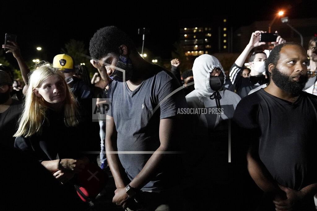 Morry Gash FILE - Protesters gather at the site of a Tuesday night shooting on Wednesday, Aug. 26, 2020 in Kenosha, Wis. A white, 17-year-old was arrested Wednesday after two people were shot to death during a third straight night of protests in Kenosha over the police shooting of a Black man, Jacob Blake. (AP Photo/Morry Gash, File)