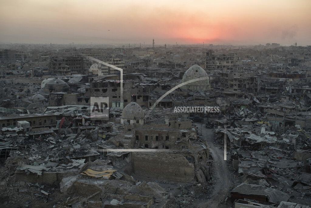 Felipe Dana FILE - In this July 11, 2017 file photo, the sun sets behind destroyed buildings in the west side of Mosul, Iraq. The 9-month fight to defeat the Islamic State group in Mosul ended in a crescendo of devastation: bombardment that damaged or destroyed a third of its historic Old City in just three weeks. The cost of uprooting the militants was the destruction of large swaths of Iraq's second largest city, leaving a population that is displaced, exhausted and potentially embittered if there is no reconstruction. (AP Photo/Felipe Dana)