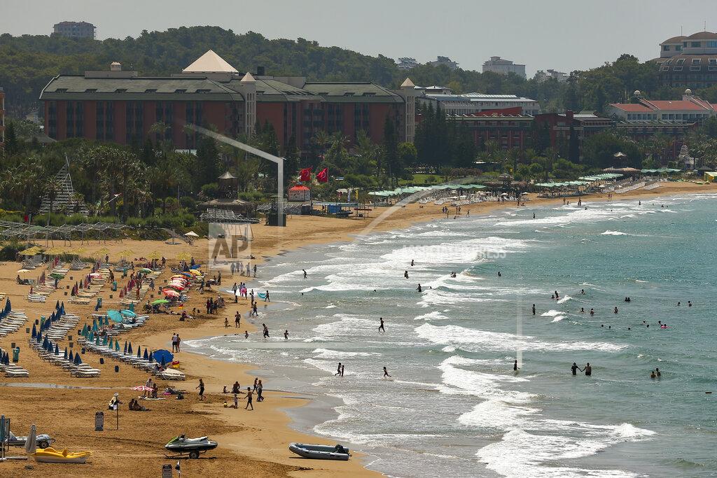 Emrah Gurel Tourists visit the beach of Antalya, southern Turkey, on Sunday, June 20, 2021. Hotels in Turkey's Antalya region, a destination beloved by holidaymakers, are preparing to finally resume operations as they expect the return of international tourists after months of setbacks caused by the pandemic that halted travel. (AP Photo/Emrah Gurel)
