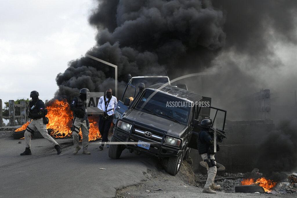 Matias Delacroix Police abandon their vehicle during a demonstration that turned violent in which protesters demanded justice for the assassinated President Jovenel Moise in Cap-Haitien, Haiti, Thursday, July 22, 2021. Demonstrations after a memorial service for Moise turned violent on Thursday afternoon with protesters shooting into the air, throwing rocks and overturning heavy concrete barricades next to the seashore as businesses closed and people took cover. (AP Photo/Matias Delacroix)