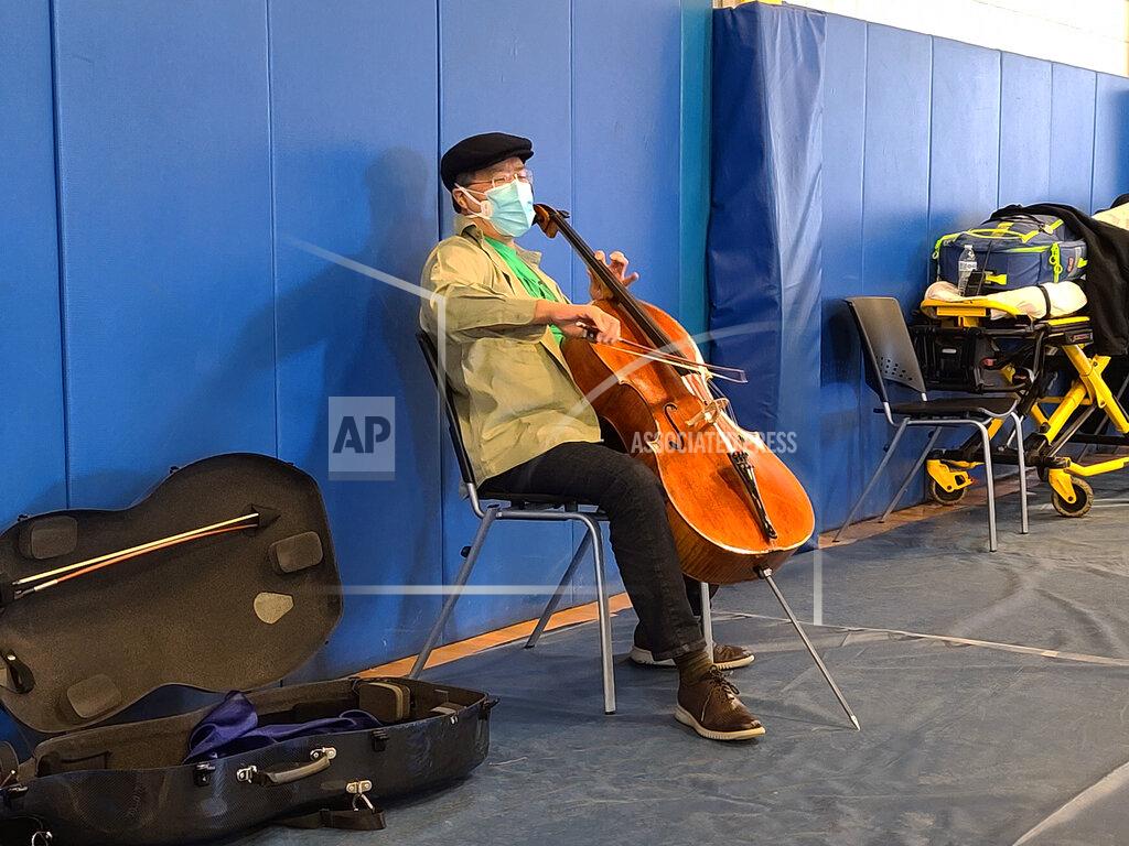 Jonah Sykes This photo provided by Berkshire Community College shows cellist Yo-Yo Ma performing at Berkshire Community College’s second dose Pfizer vaccination clinic in the Paterson Field House on Saturday, March 13, 2021 in Pittsfield, Mass. Newly vaccinated Massachusetts residents were treated to a mini concert when the famed cellist brought out his instrument after getting his second shot. (Jonah Sykes/Berkshire Community College via AP)