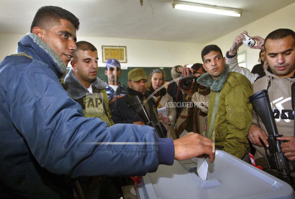 Brennan Linsley FILE - In this Jan. 9, 2005 file photo, Zakaria Zubeidi, then West Bank leader of Palestinian militant group Al Aqsa Martyrs Brigades votes during the Palestinian election, in the West Bank town of Jenin. For nearly two decades, Zubeidi has been an object of fascination for Israelis and Palestinians alike, who have seen his progression from a child actor to a swaggering militant, to the scarred face of a West Bank theater promoting “cultural resistance” to Israeli occupation. In his latest act, he has emerged as one of Israel's most wanted fugitives after tunneling out of a high-security prison on Monday, Sept. 6, 2021 with five other Palestinian militants. (AP Photo/Brennan Linsley)