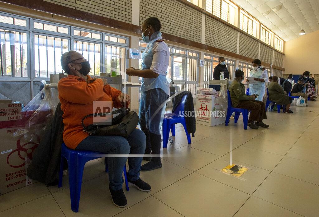 Themba Hadebe Thoko Hlongwane, waits to be vaccinated as a nurse prepares a dose of the Pfizer COVID-19 vaccine at Chris Hani Baragwanath Academic Hospital in Soweto, South Africa, Monday, May 17, 2021. South Africa has started its mass vaccination drive with the goal of inoculating nearly 5 million citizens aged 60 and above by the end of June. (AP Photo/Themba Hadebe)