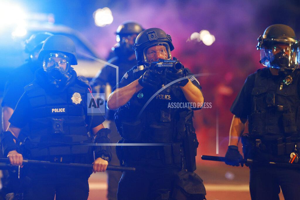 David Zalubowski Denver police fire canisters to disperse a protest outside the State Capitol over the death of George Floyd, a handcuffed black man in police custody in Minneapolis, Thursday, May 28, 2020, in Denver. (AP Photo/David Zalubowski)