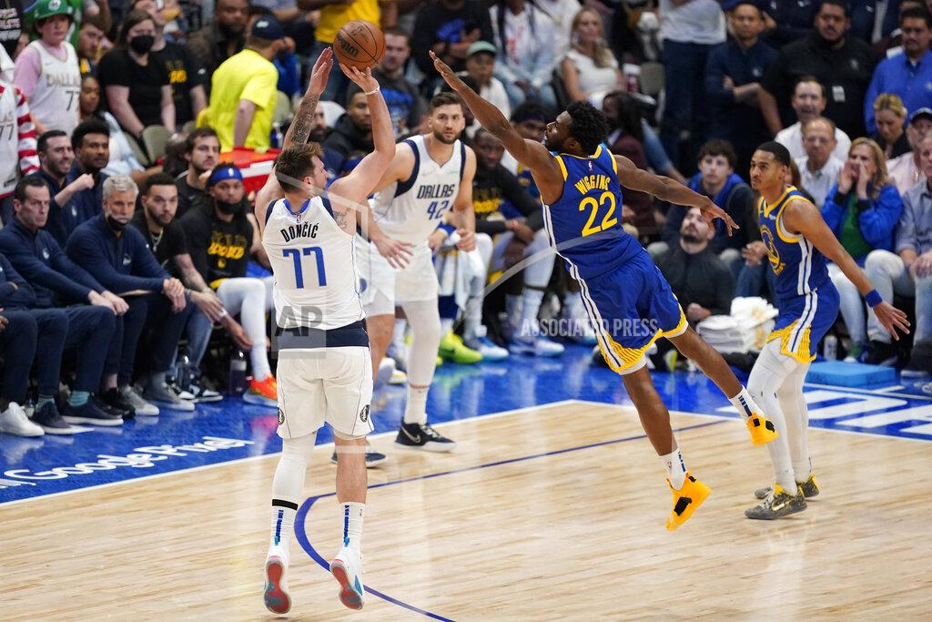 Tony Gutierrez Dallas Mavericks guard Luka Doncic shoots a 3-point basket over the stretched arms of Golden State Warriors forward Andrew Wiggins during the second half of Game 4 of the NBA basketball playoffs Western Conference finals, Tuesday, May 24, 2022, in Dallas. (AP Photo/Tony Gutierrez)