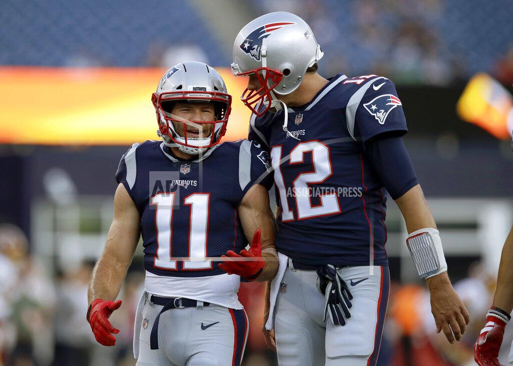 FILE - In this Aug. 9, 2018, file photo, New England Patriots wide receiver Julian Edelman (11) talks with quarterback Tom Brady (12) before a preseason NFL football game against the Washington Redskins in Foxborough, Mass. There’s just two receivers in NFL postseason history with over 100 catches – Jerry Rice with 151 and Edelman with 105. That link has only been strengthened off the field in the past year as Brady and Edelman prepare to play in their fourth Super Bowl together. (AP Photo/Charles Krupa, File)