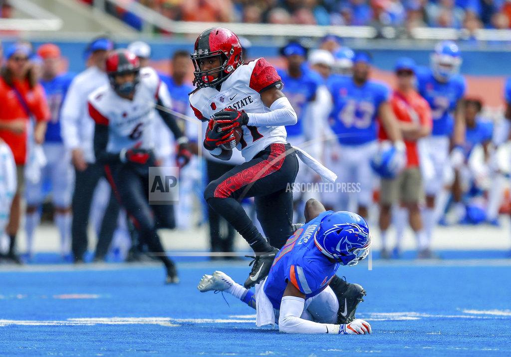 Steve Conner San Diego State wide receiver BJ Busbee, left, avoids the tackle attempt by Boise State safety Tyreque Jones, on the ground, in the first half of an NCAA college football game, Saturday, Oct. 6, 2018, in Boise, Idaho. (AP Photo/Steve Conner)