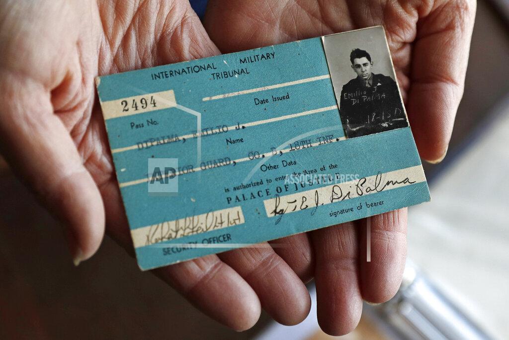 Charles Krupa Emily DiPalma Aho holds the Palace of Justice building pass of her father, World War II veteran Emilio DiPalma, at her home in Jaffrey, N.H., Wednesday, May 13, 2020. Emilio DiPalma, who as a 19-year-old U.S. Army infantryman stood guard at the Nuremberg Nazi war crimes trials, died last month at the age of 93 after contracting the coronavirus at Holyoke Soldiers' Home in Massachusetts. (AP Photo/Charles Krupa)