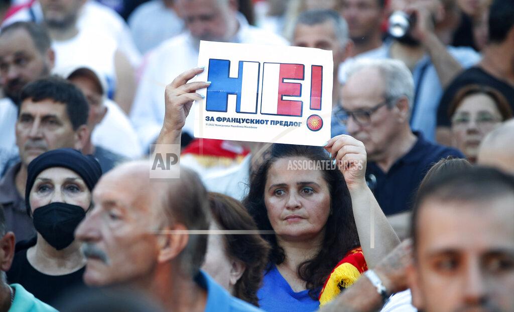 Boris Grdanoski A woman holds a banner reading "No for the French proposal" in Macedonian, during a protest in front of the government building in Skopje, North Macedonia, on Saturday, July 2, 2022. Tens of thousands of people have gathered late on Saturday in North Macedonia's capital Skopje to protest the latest French presidency proposal on solving bilateral disputes with Bulgaria that gave directions for small Balkan country to open membership talks with the European Union. (AP Photo/Boris Grdanoski)