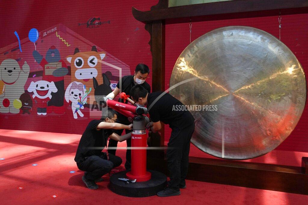 Ng Han Guan Workers dismantle a robot arm used in sounding a gong at a ceremony to virtually observe the listing of JD Logistics on the Hong Kong stock exchange from the JD.com headquarters in Beijing on Friday, May 28, 2021. JD Logistics' shares jumped 14% in their trading debut Friday in Hong Kong. The company is a subsidiary of Chinese e-commerce giant JD.com. It is the latest technology company to list in the semi-autonomous Chinese city as Beijing intensifies scrutiny of the technology sector. (AP Photo/Ng Han Guan)