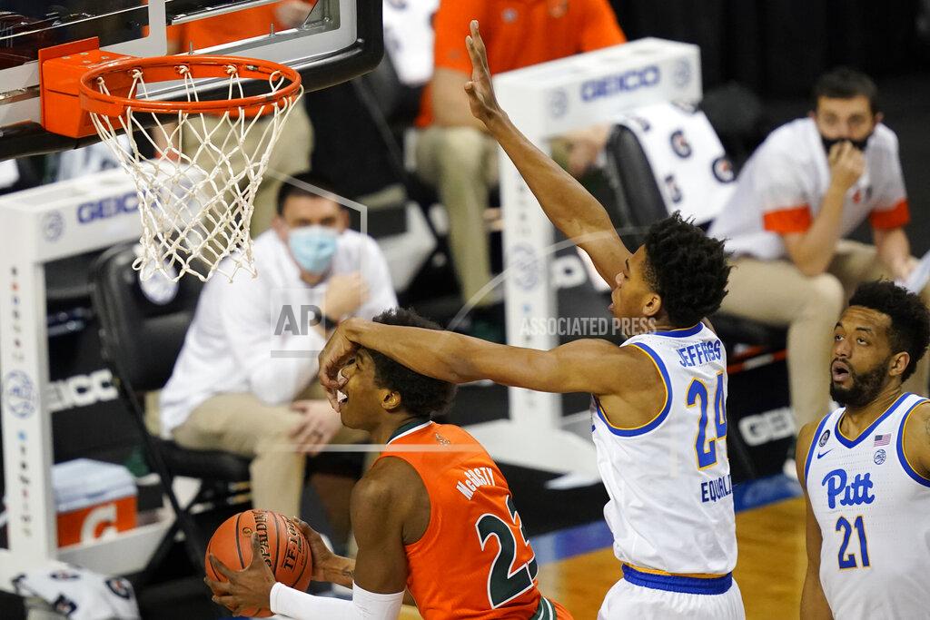Gerry Broome Pittsburgh guard William Jeffress (24) gets his hand in the face of Miami (Fl) guard Kameron McGusty (23) during the second half an NCAA college basketball game in the first round of the Atlantic Coast Conference tournament in Greensboro, N.C., Tuesday, March 9, 2021. (AP Photo/Gerry Broome)