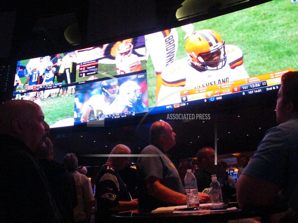 Wayne Parry This Sept. 9, 2018 photo shows football fans watching the action on wall-mounted video screens in the sports betting lounge at the Ocean Resort Casino in Atlantic City, N.J. A report released Feb. 2, 2021 by the American Gaming Association predicts fewer Americans will bet on this year's Super Bowl, a decrease driven largely by fewer people back at work in offices where betting pools are circulated. But the report also predicts a record amount will be wagered online this year. (AP Photo/Wayne Parry)