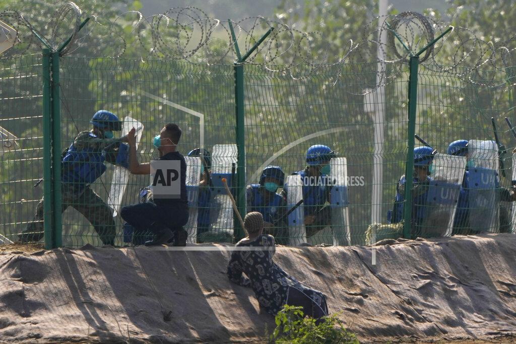 Ng Han Guan Participants in the role of refugees escaping fighting plead for help outside a United Nations compound during the Shared Destiny 2021 drill at the Queshan Peacekeeping Operation training base in Queshan County in central China's Henan province Wednesday, Sept. 15, 2021. Peacekeeping troops from China, Thailand, Mongolia and Pakistan took part in the 10 days long exercise that field reconnaissance, armed escort, response to terrorist attacks, medical evacuation and epidemic control. (AP Photo/Ng Han Guan)