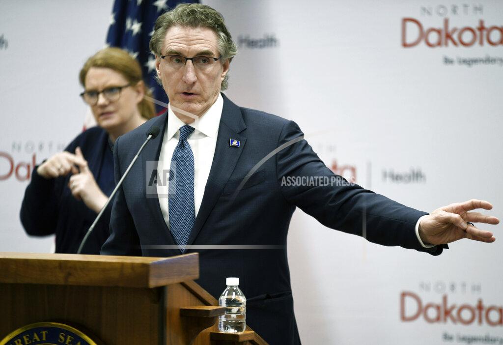 Mike Mccleary FILE - In this March 27, 2020 file photo, North Dakota Gov. Doug Burgum speaks during a news conference at the state Capitol in Bismarck, N.D. North Dakota spent a record amount of cash on merit bonuses for some state workers, despite a grim financial outlook caused by the coronavirus pandemic, records show.Most of the money was paid at the end of the fiscal year that ended June 30, and just weeks after Gov. Doug Burgum said the state was in a financial crisis. (Mike McCleary/The Bismarck Tribune via AP, File)_